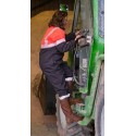 Descente d'une agricultrice d'un engin combinaison rouge fluo
