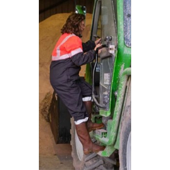 Descente d'une agricultrice d'un engin combinaison rouge fluo